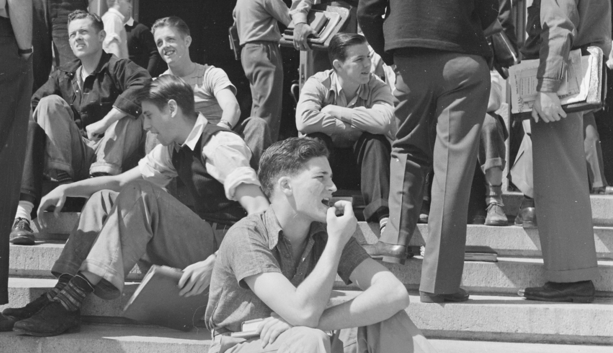 A black and white photo of male students sitting on the steps of Wheeler Hall on the University of California, Berkeley campus in 1940. 