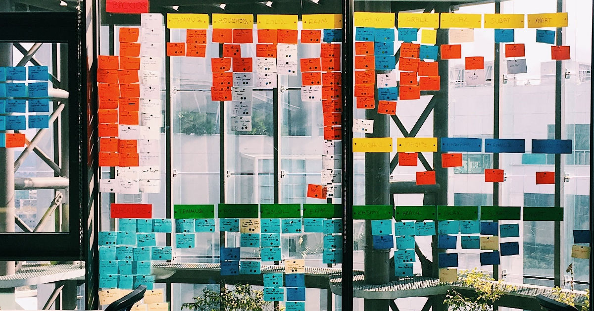 Colorful sticky notes arranged in a grid on the window of an office building.