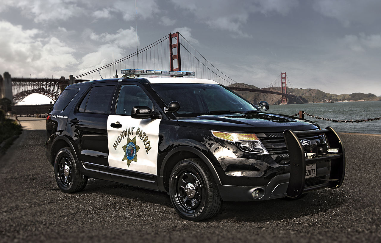 A sports utility vehicle belonging to the California Highway Patrol is parked in front of the Golden Gate Bridge.